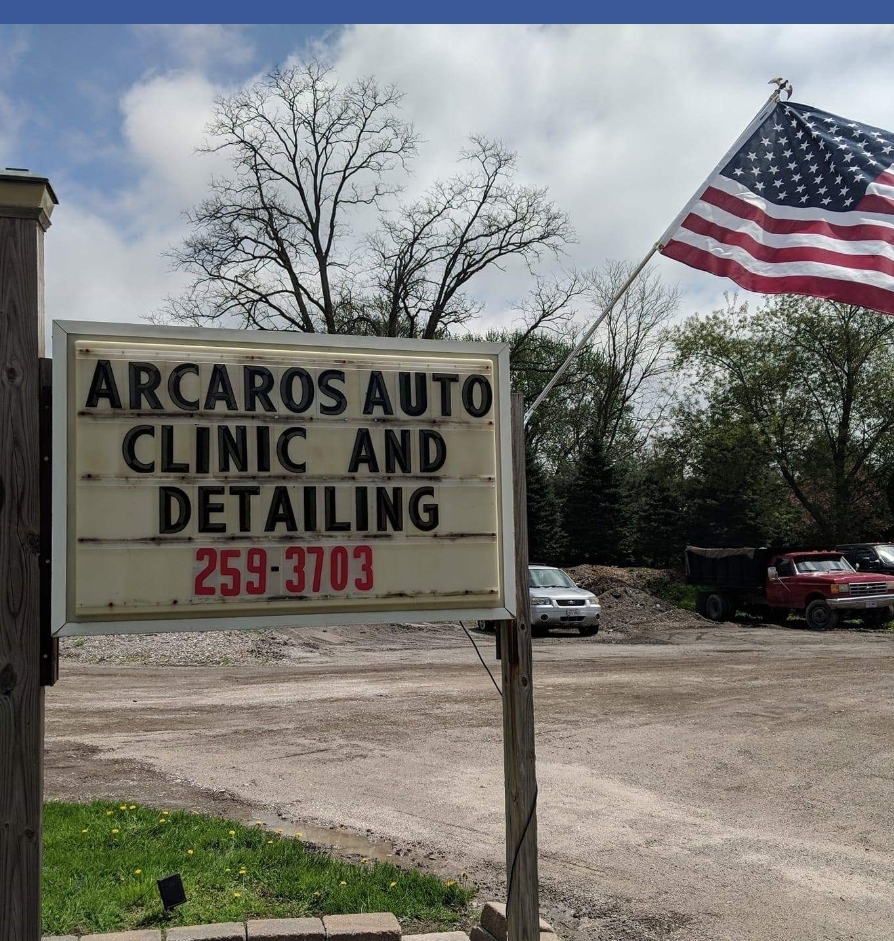 Arcaro's Auto Clinic & Detailing roadside sign with American flag